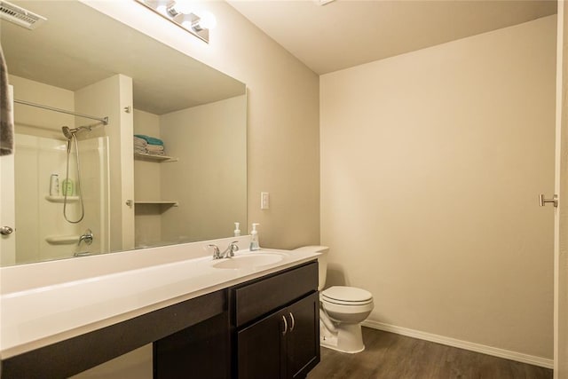 bathroom featuring vanity, toilet, hardwood / wood-style floors, and a shower