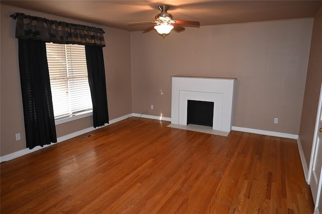 unfurnished living room featuring ceiling fan and hardwood / wood-style floors