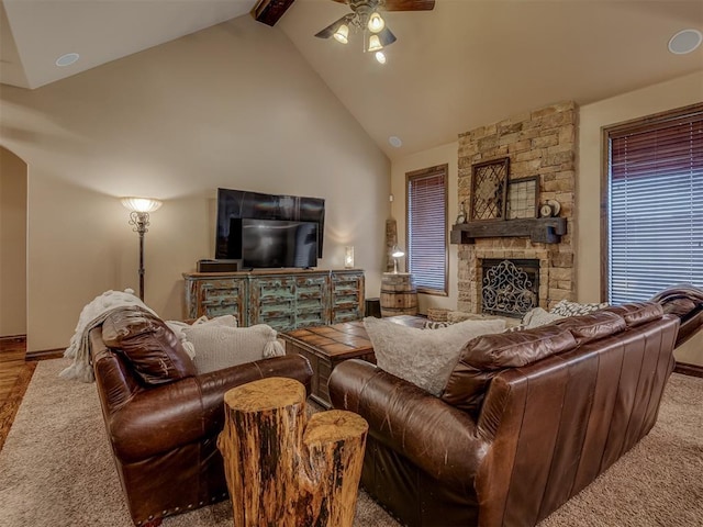 living room featuring ceiling fan, a fireplace, high vaulted ceiling, and beam ceiling