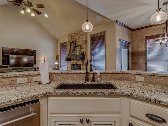 kitchen with dishwasher, lofted ceiling, sink, hanging light fixtures, and light stone counters