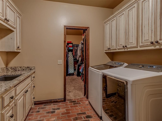 clothes washing area featuring cabinets and washing machine and dryer