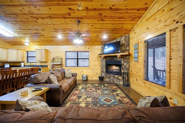 living room with wood ceiling, wooden walls, vaulted ceiling, and a stone fireplace