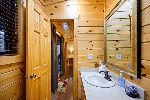 bathroom with vanity, lofted ceiling, wooden ceiling, and wooden walls