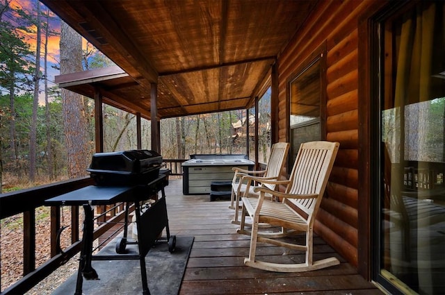 deck at dusk with a hot tub