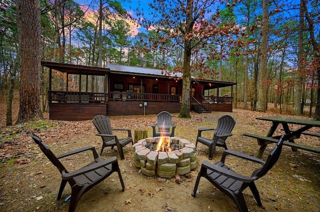 back house at dusk with an outdoor fire pit