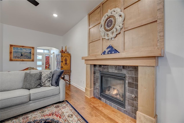 living room with a tile fireplace and light hardwood / wood-style floors