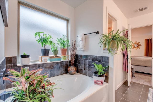 bathroom featuring a washtub and tile patterned floors