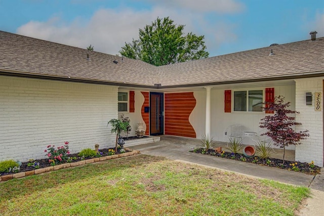 entrance to property with a lawn