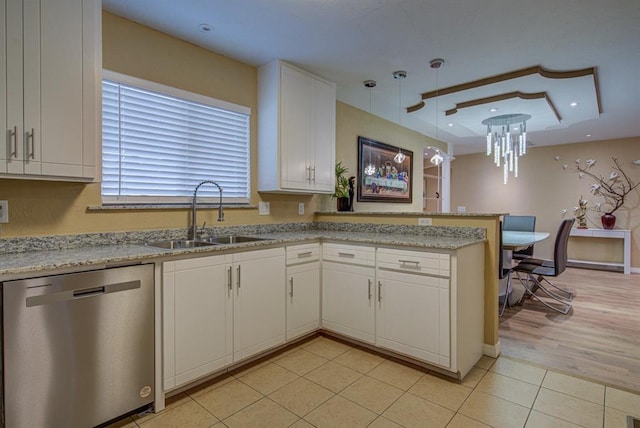 kitchen featuring dishwasher, sink, white cabinets, hanging light fixtures, and kitchen peninsula