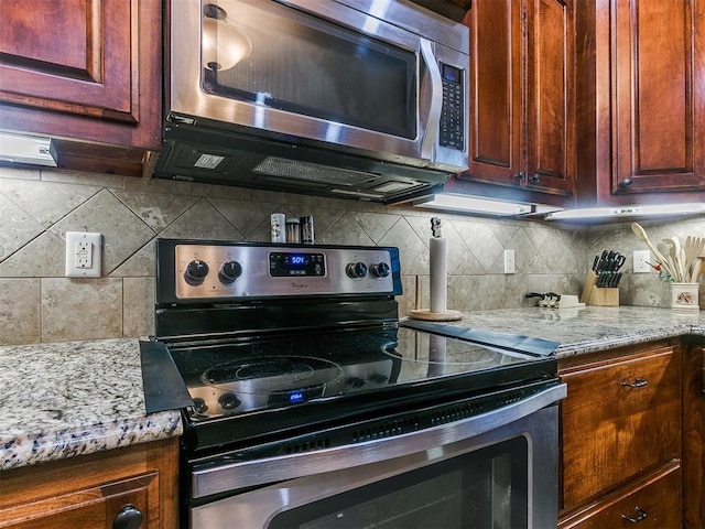 kitchen featuring tasteful backsplash, stainless steel appliances, and light stone countertops