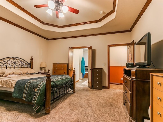 bedroom with a tray ceiling, crown molding, light colored carpet, and ceiling fan