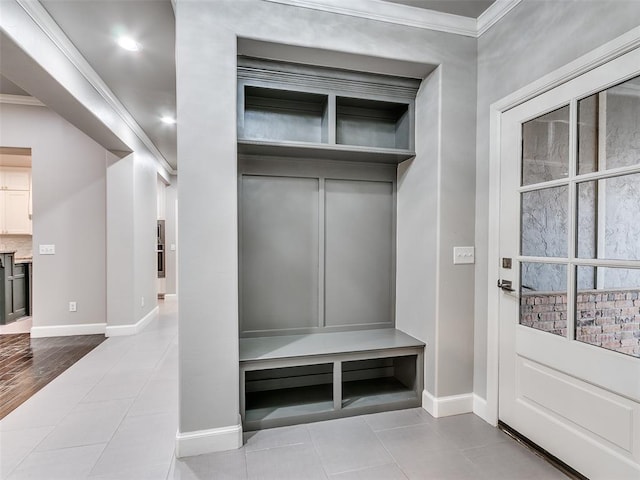 mudroom with crown molding and light tile patterned flooring