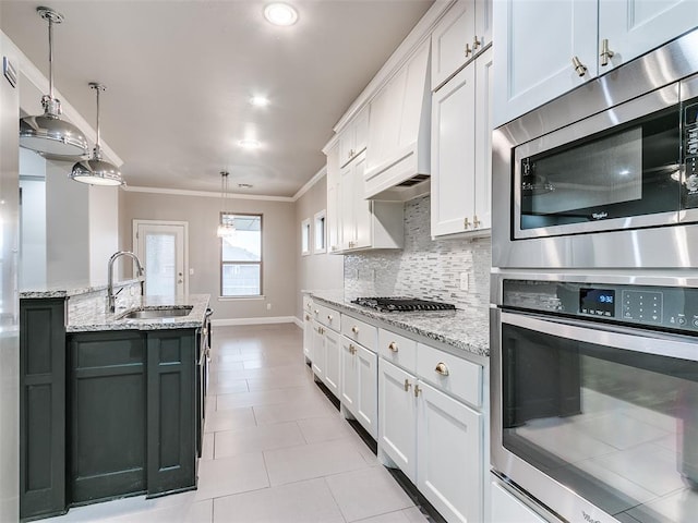 kitchen featuring pendant lighting, stainless steel appliances, sink, and white cabinets