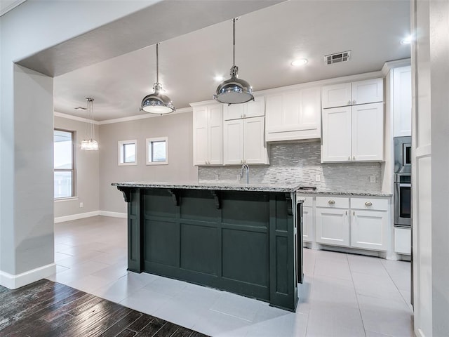 kitchen with white cabinetry, tasteful backsplash, appliances with stainless steel finishes, and light stone counters