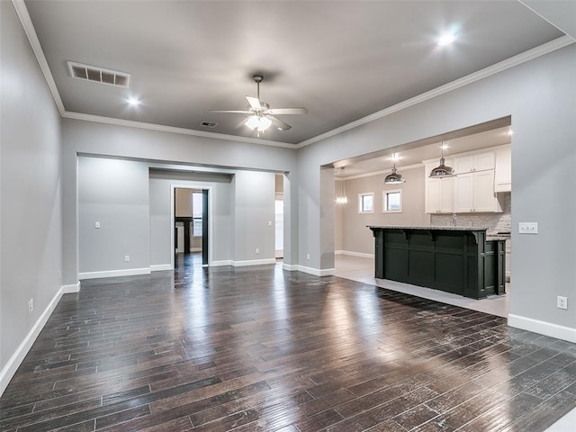 unfurnished living room with crown molding, dark hardwood / wood-style floors, and ceiling fan with notable chandelier