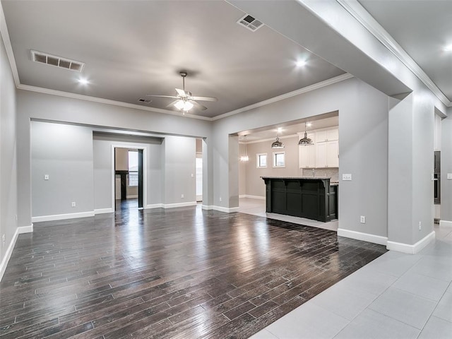 unfurnished living room with ornamental molding, dark hardwood / wood-style floors, and ceiling fan