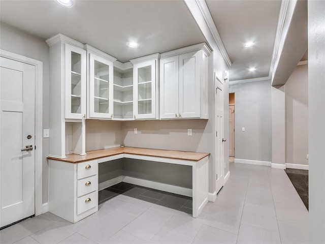 kitchen with white cabinetry, light tile patterned floors, and crown molding