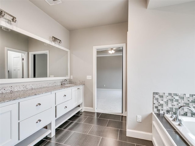 bathroom featuring vanity, a tub, and ceiling fan