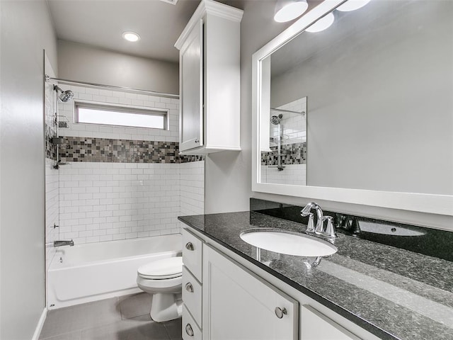 full bathroom featuring tiled shower / bath combo, vanity, tile patterned floors, and toilet