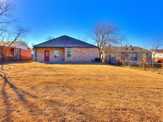 back of house with a yard and central air condition unit