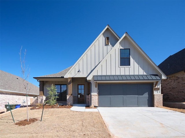 view of front of house featuring driveway, a garage, a standing seam roof, board and batten siding, and brick siding