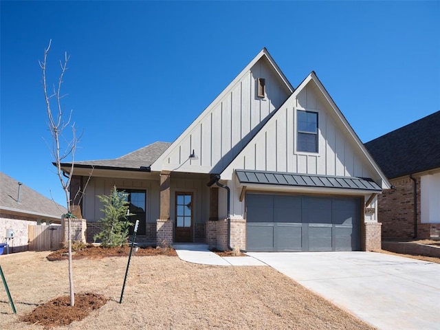 view of front of property with board and batten siding, a standing seam roof, brick siding, and driveway