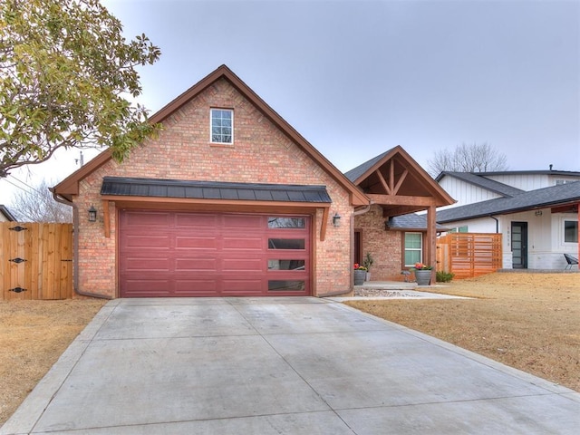 view of front of property featuring concrete driveway, brick siding, and fence