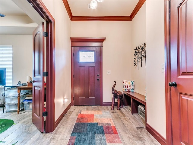 entryway featuring baseboards, wood finish floors, and crown molding