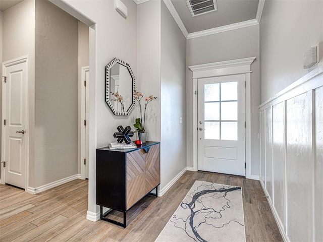 foyer with hardwood / wood-style flooring and ornamental molding