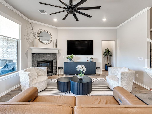 living room featuring hardwood / wood-style flooring, ornamental molding, and a fireplace