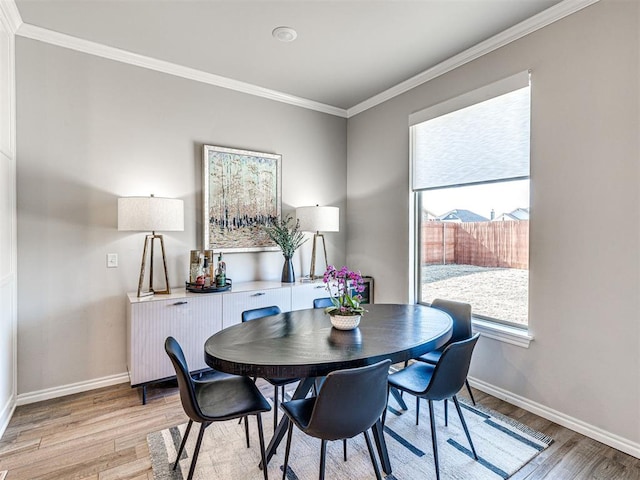 dining area featuring ornamental molding, radiator, and light hardwood / wood-style flooring