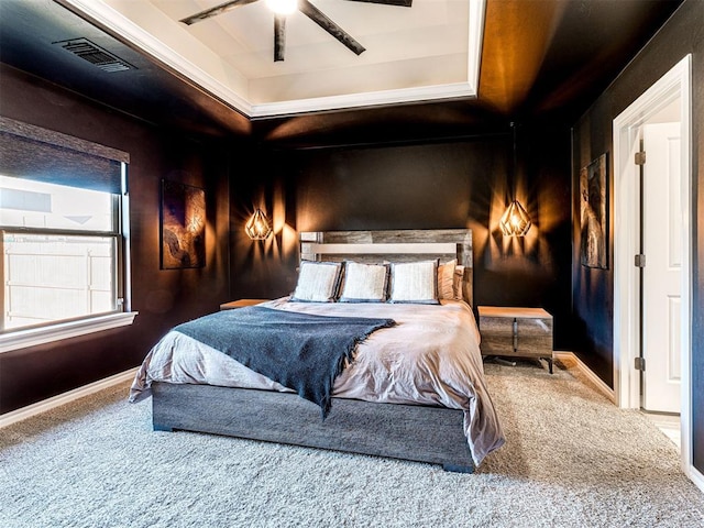 bedroom with a raised ceiling, ceiling fan, and carpet