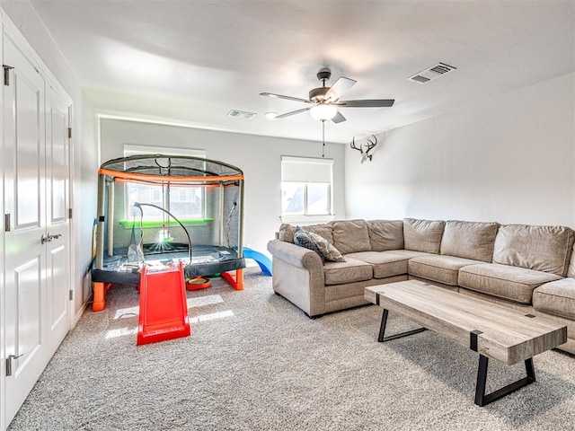 carpeted living room with ceiling fan