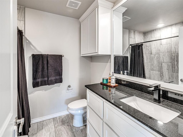 bathroom with vanity, toilet, and curtained shower