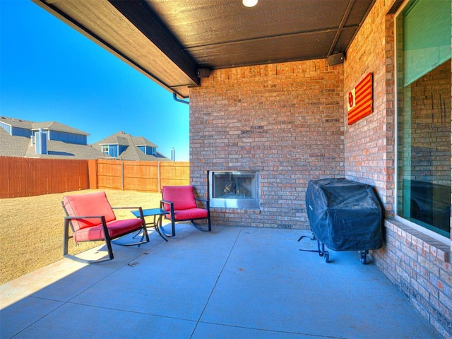 view of patio featuring an outdoor brick fireplace and area for grilling