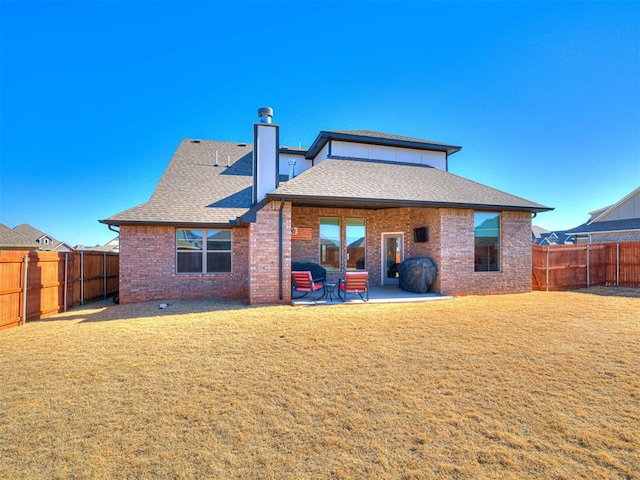 back of house featuring a lawn and a patio area