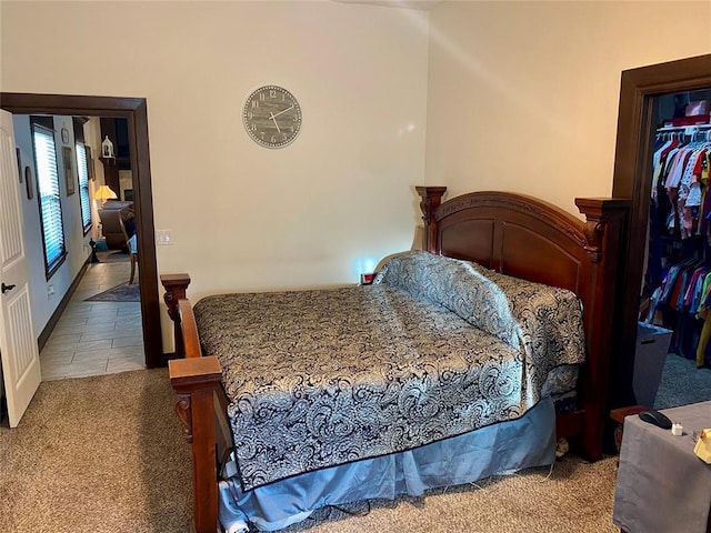 bedroom with light carpet and a walk in closet