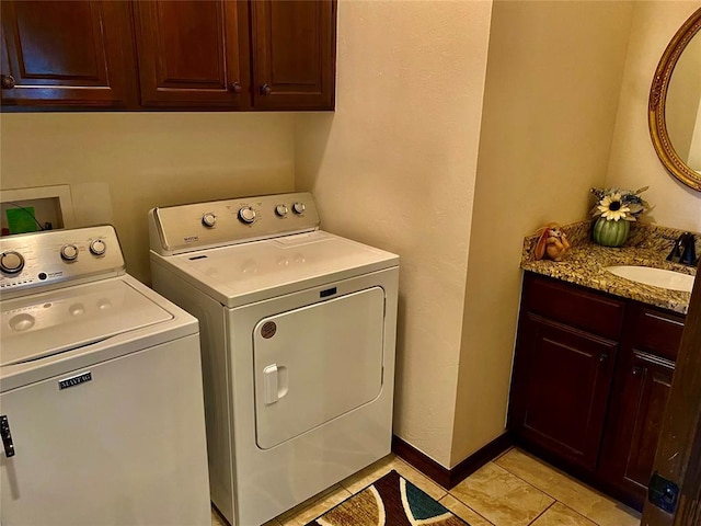 clothes washing area featuring sink, light tile patterned floors, washer and clothes dryer, and cabinets