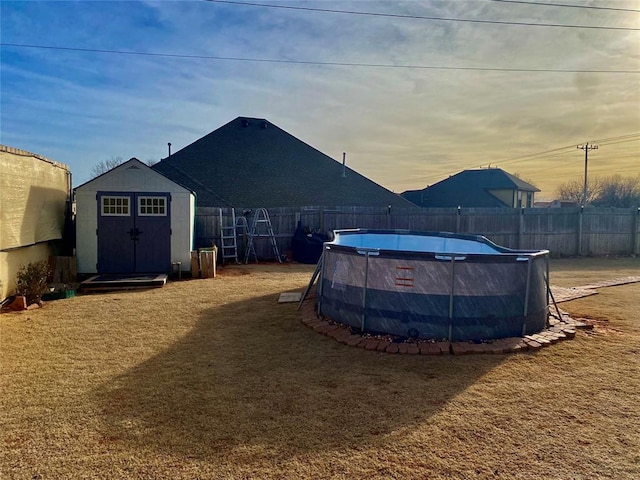 yard at dusk featuring a shed and a fenced in pool