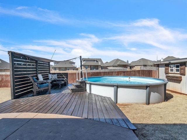 view of pool featuring a fenced in pool, a residential view, fence, and a wooden deck