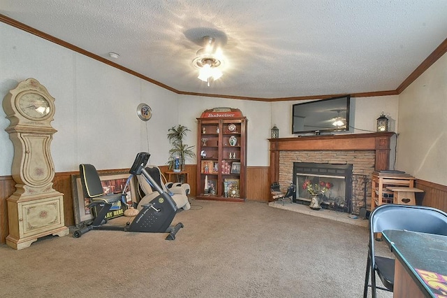 interior space featuring carpet flooring, ornamental molding, a textured ceiling, a stone fireplace, and wood walls