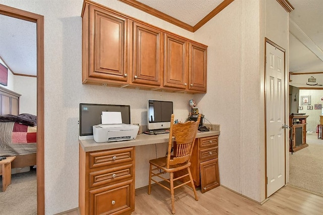 home office with crown molding, built in desk, and light hardwood / wood-style floors