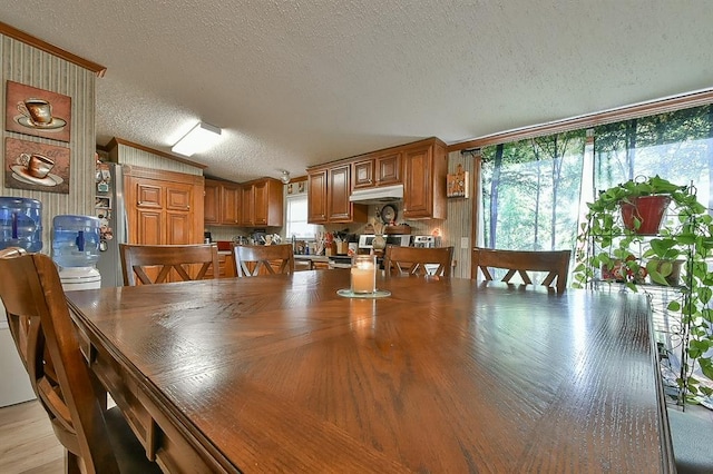 dining space featuring vaulted ceiling and a textured ceiling