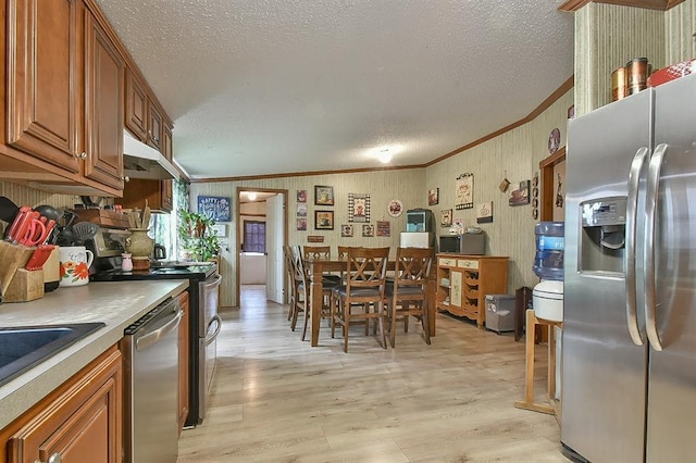 kitchen featuring sink, crown molding, light hardwood / wood-style flooring, stainless steel appliances, and a textured ceiling