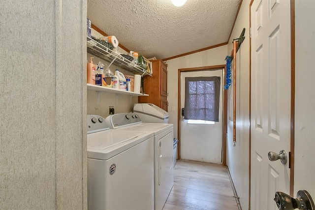 laundry area with cabinets, washer and clothes dryer, light hardwood / wood-style flooring, and a textured ceiling