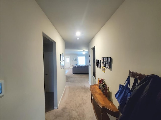 hallway with light carpet and baseboards