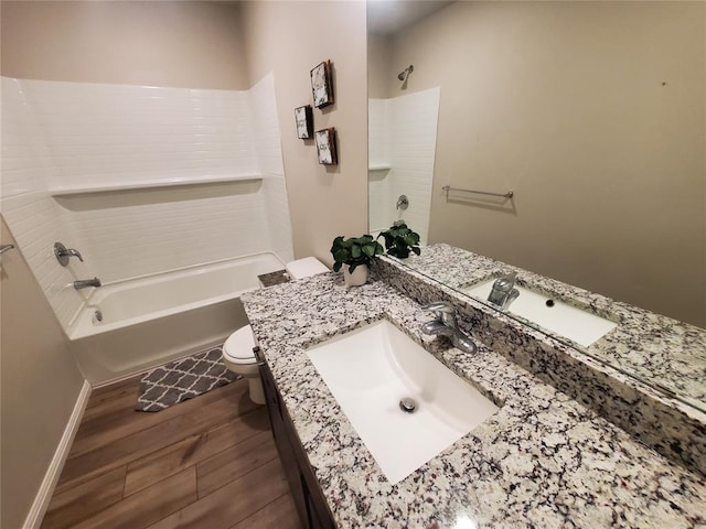 bathroom with toilet, shower / bath combination, wood finished floors, vanity, and baseboards