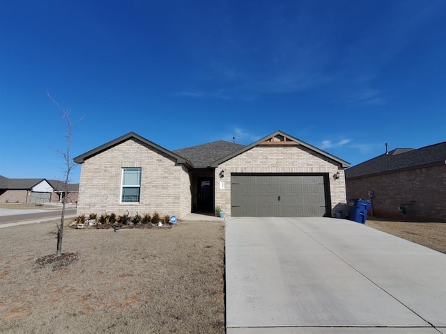 single story home featuring concrete driveway, brick siding, and an attached garage