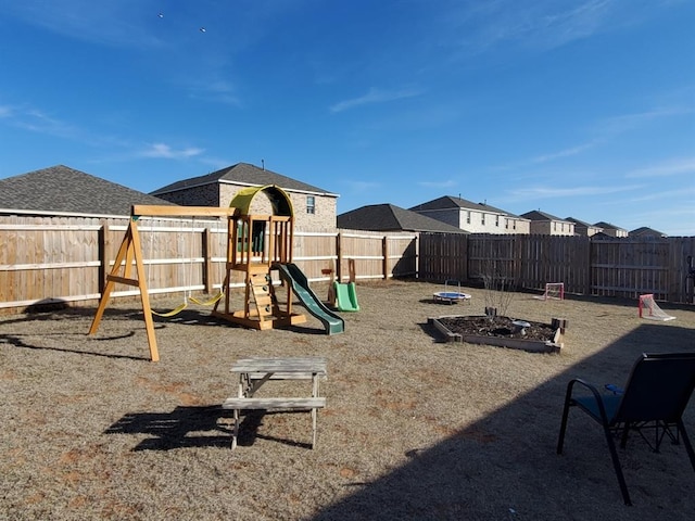 view of play area with a fenced backyard and a garden