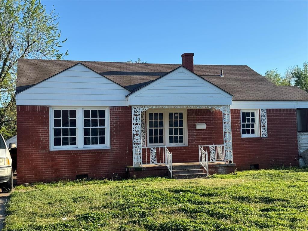 rear view of house featuring a yard